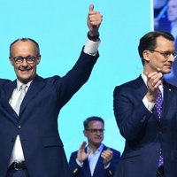 Merz und Wüst nach der Bundestagswahl jubelnd auf einer Bühne