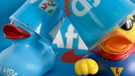 Zwei Badeenten mit AfD-Logo und Farbe haben einen Eierlikör-Becher der AfD falsch herum auf dem Kopf