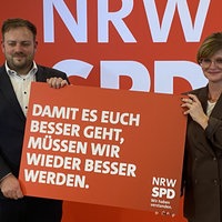 Sarah Philipp und Frederick Cordes bei einem Pressetermin mit einem Schild zur Kampagne "Wir haben verstanden."