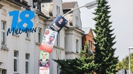 Bild von einer über die Biegung hinausgehenden Plakatierung einer Straßenlaterne in Bonn