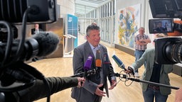 Gordan Dudas (SPD) spricht in mehrere Mikrofone vor dem Saal des Untersuchungsausschusses