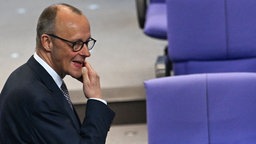 Friedrich Merz im Bundestag, er schaut nachdenklich, hält sich das Kinn
