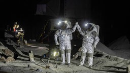 Zwei Astronauten simulieren in der Anlage LUNA eine Arbeitsaktion auf dem Mond