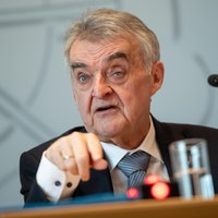 Herbert Reul, NRW- Innenminister, spricht an einem Tisch sitzend in ein Mikrofon einer Pressekonferenz.