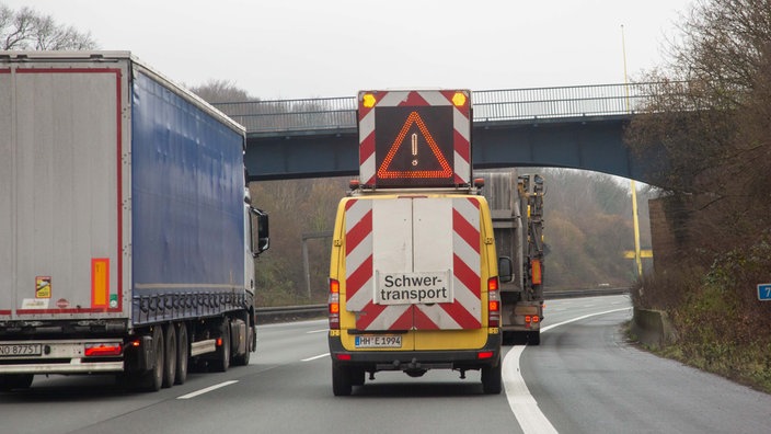 Duisburg, 15.12.2021. Schwertransport auf der Autobahn A3 Höhe Duisburg in Richtung Frankfurt. Bild: LKW, PKW, Schriftzug "Schwertransport", Warndreieck, Rückansicht
