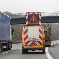 Duisburg, 15.12.2021. Schwertransport auf der Autobahn A3 Höhe Duisburg in Richtung Frankfurt. Bild: LKW, PKW, Schriftzug "Schwertransport", Warndreieck, Rückansicht