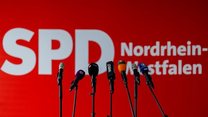  Mikrofone von Fernsehsendern stehen vor dem Logo der SPD im Johannes-Rau-Haus, der Parteizentrale, vor einem Statement der Parteivorsitzenden zu den Kommunalwahlen.