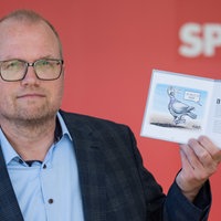 Der SPD-Fraktionschef im Landtag, Jochen Ott, hält eine Broschüre mit Karikaturen zu einem Jahr Schwarz-Grün hoch