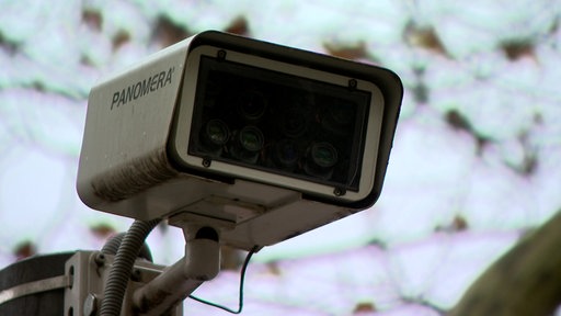 Videokamera mit Aufschrift Panomera im Hintergrund Himmel und Blätter unscharf