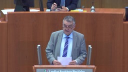 Reul am Rednerpult im Landtag, Papier in der Hand 