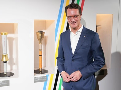 NRW-Ministerpräsident Hendrik Wüst (CDU) neben olympischen Fackeln im Deutschen Sport und Olympia-Muesum in Köln