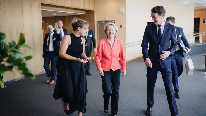 Mona Neubaur (Grüne), Henrdik Wüst (CDU) und Ursula von der Leyen (CDU) im EU-Kommissionsgebäude