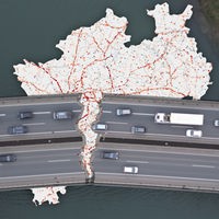 Karte von NRW mit roten und blauen Punkten, davor eine zerbrochene Brücke
