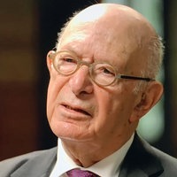 Portraitfoto von Bert Woudstra. Er trägt einen Anzug und eine runde Brille.
