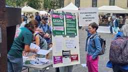 Auf einem Platz stehen Demonstranten die Unterschriften sammeln