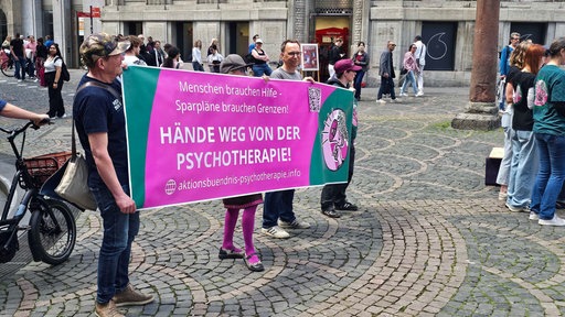 Auf einem Banner steht: "Hände weg von der Psychotherapie!"