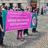 Auf einem Banner steht: "Hände weg von der Psychotherapie!"