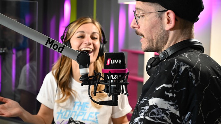Zwei Menschen am Studio-Mikrofon von 1LIVE
