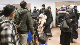 Asylbewerber warten um einen Asylantrag zu stellen