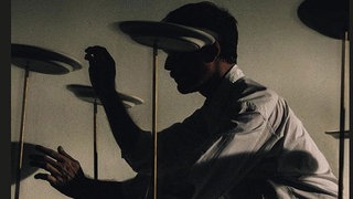 cover James Blake: "Trying Times" - ein Mann im Schatten am Schlagzeug. 