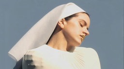 ROSALÍA: "LUX" - die Sängerin als Nonne auf dem Cover; die Arme verschränkt, in einer weißen Zwangsweste. 