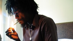Seu Jorge zündet sich eine Zigarette an
