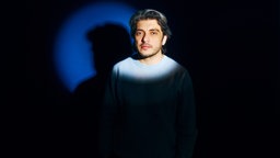 Porträtaufnahme von Khesrau Behroz mit verschränkten Armen