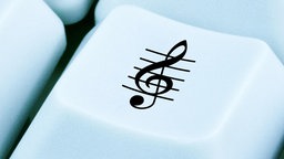 Eine Musiknote ist auf einer Computertastatur zu sehen.