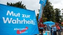 Passanten stehen am 01.09.2016 in Schwerin (Mecklenburg-Vorpommern) bei der Kundgebung zum Abschluss des AfD-Wahlkampfs in Mecklenburg-Vorpommern an einem Infostand der AfD