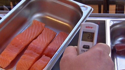 Bei einer Lebensmittelkontrolle wird Lachs auf seine Temperatur getestet.
