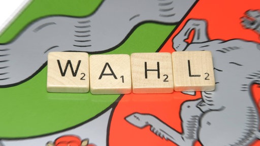 Aus Scrabble-Spielsteinen gebildeter Schriftzug "Wahl" liegt auf dem Wappen des Bundesland Nordrhein-Westfalen