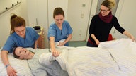 In der Lernklinik erhalten die Studentinnenvom bundesweit einmaligen Pflege-und Modellstudiengang "Evidenzbasierte Pflege" von der Praxisanleiterin an einer Puppe Anleitung zur Grundpflege