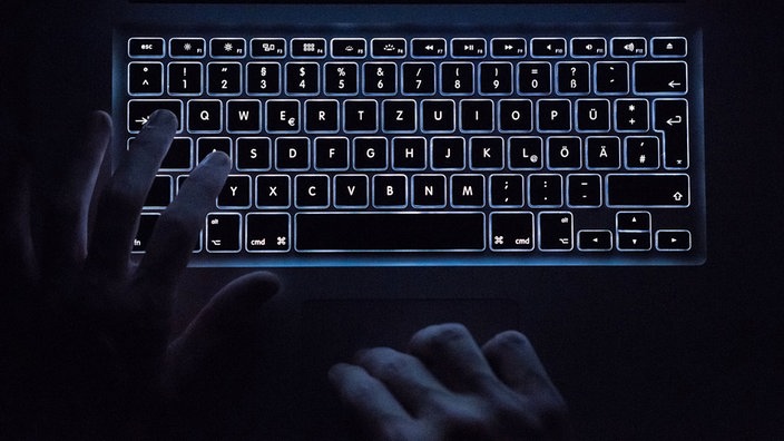 Tastatura sa pozadinskim osvetljenjem i ruke u mraku