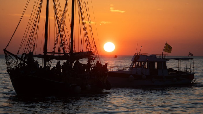 Turisti na brodu gledaju zalazak sunca