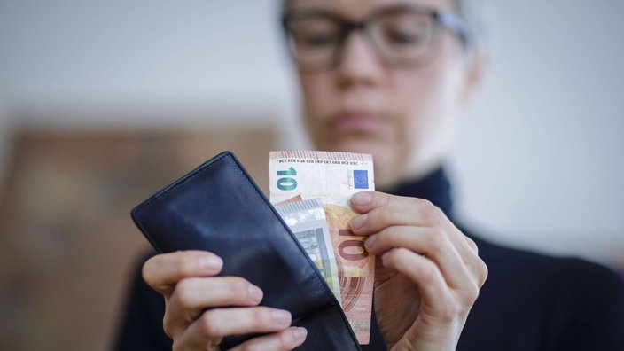 Žena slaže novčanice u novčanik