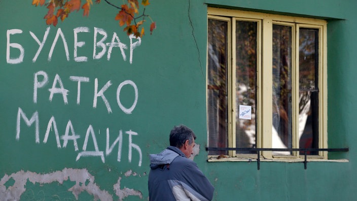 Prolaznik pored zida na kome je bojom napisano “Bulevar Ratko Mladić“ u Srbiji