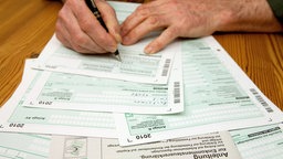 Eine Seniorin füllt eine Steuererklärung aus