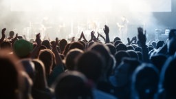 Viele Menschen jubeln vor einer Konzertbühne