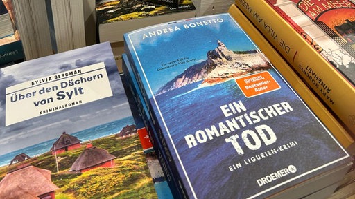 Mehrere Bücher auf einem Tisch, darunter "Ein romantische Tod" von Andrea Bonetto