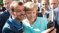 Angela Mrkel fa un selfie con un rifugiato
