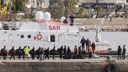 Migranten besteigen im Hafen von Shengjin im Nordwesten Albaniens ein Schiff der italienischen Küstenwache, das sie nach einer Gerichtsentscheidung in Rom aus Lagern in Albanien nach Italien bringt. 