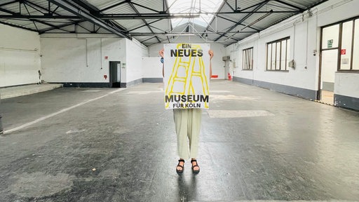 Wuartier am Hafen: Ein Mensch hebt ein Schild zum Event: TEMPO___K