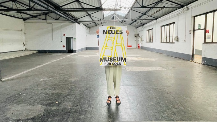 Wuartier am Hafen: Ein Mensch hebt ein Schild zum Event: TEMPO___K