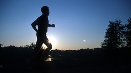 Ein Jogger unterwegs bei Sonnenaufgang