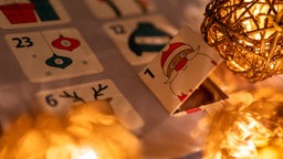 Bei einem Adventskalender mit Schokoladenfiguren ist das erste Türchen geöffnet.