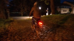Archivfoto vom 02.12.2024: Ein Jugendlicher auf dem Fahrrad in der Nacht.