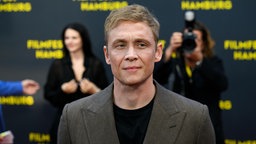 Matthias Schweighöfer steht am 28.09.2025 vor einer Wand mit dem Schriftzug "Filmfest Hamburg"