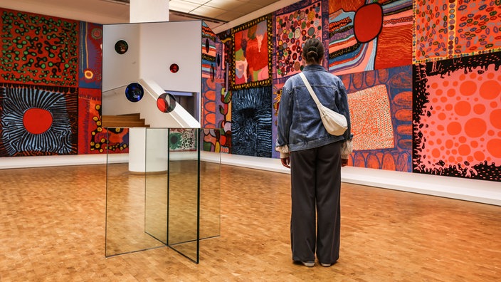 Ausstellung im Museum Ludwig - Yayoi Kusama: Eine Frau steht vor der Installation "My eternal soul"