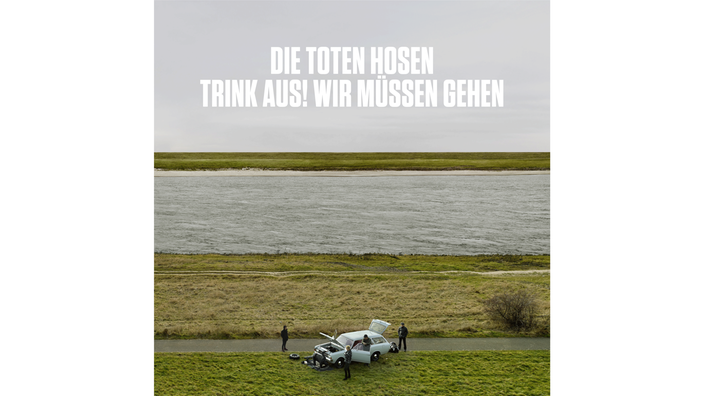 Album-Cover von Die Toten Hosen: "Trink aus, wir müssen gehen!" Man sieht darauf ein Auto, das bei der Reparatur am Rhein steht.