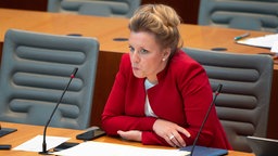 Brands stützt sich bei einer Sitzung im NRW-Landtag am 27.03.2025 mit den Ellebogen auf den Tisch. Sie wirkt konzentriert.